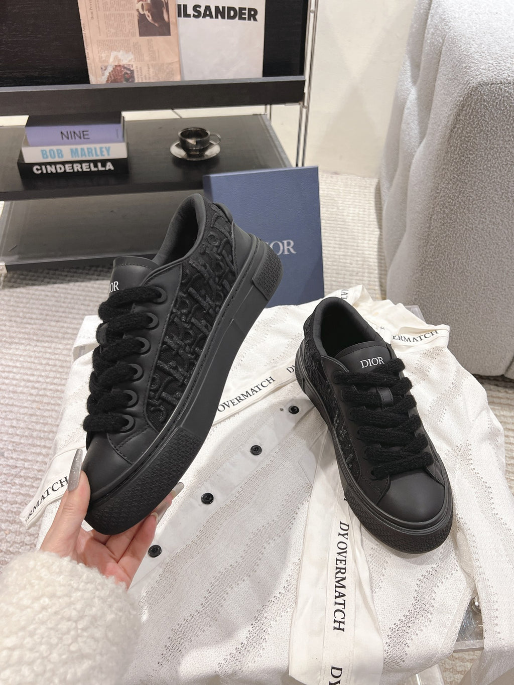 Black Dior sneakers with thick sole and embossed pattern on sides.