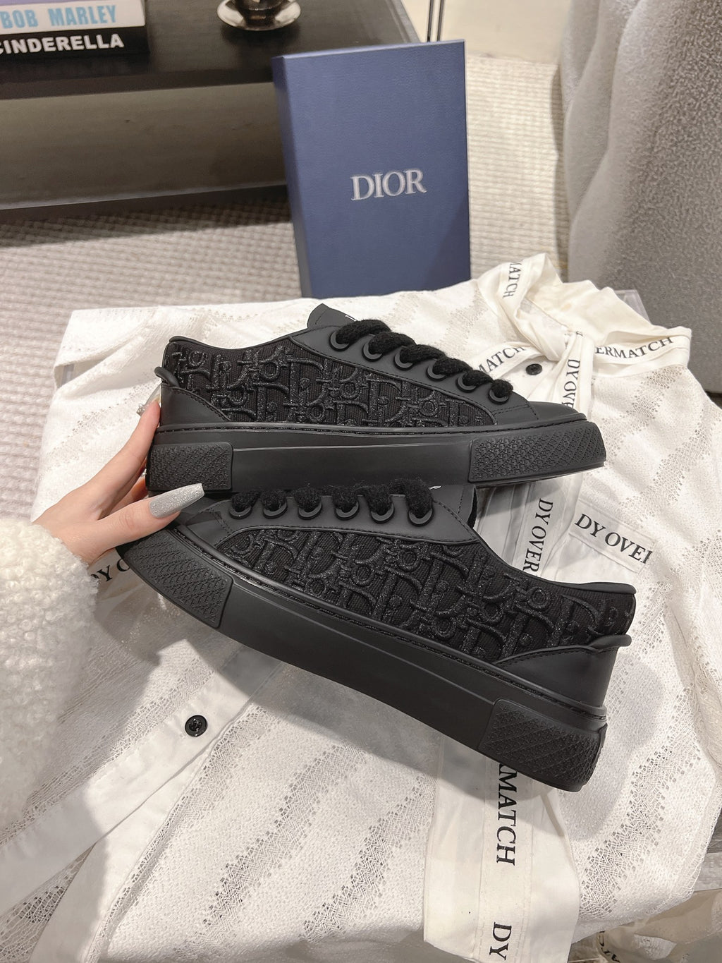Black Dior low-top sneakers with embossed pattern and thick platform sole.