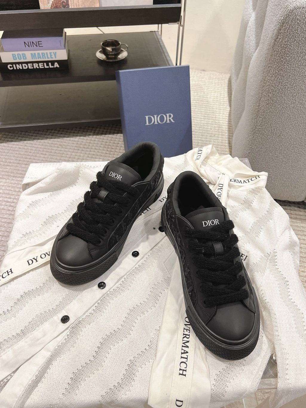 Black Dior low-top sneakers, front view with lace-up closure and round toe.