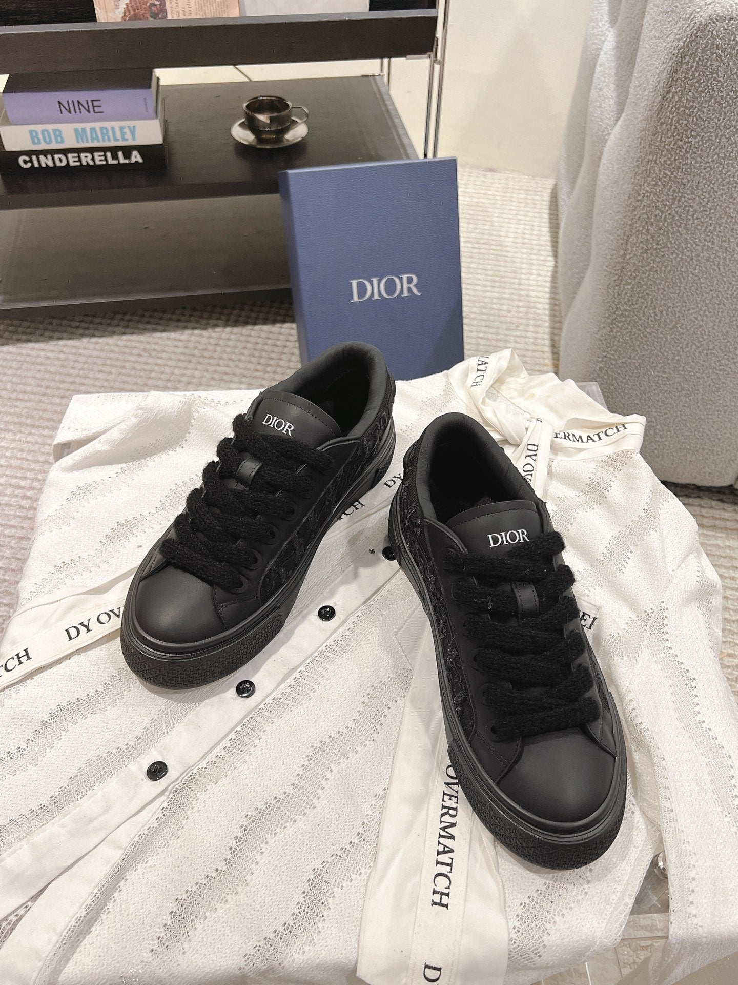 Black Dior low-top sneakers, front view with lace-up closure and round toe.
