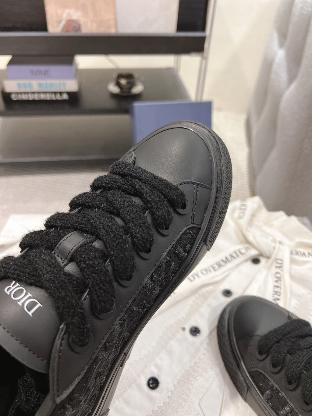 Close-up of black Dior lace-up sneaker upper with textured detailing.
