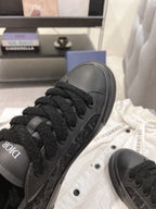 Close-up of black Dior lace-up sneaker upper with textured detailing.