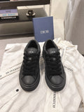 Black low-top sneakers with Dior logo on tongue and lace-up front.