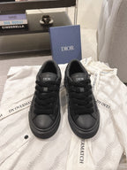 Black low-top sneakers with Dior logo on tongue and lace-up front.