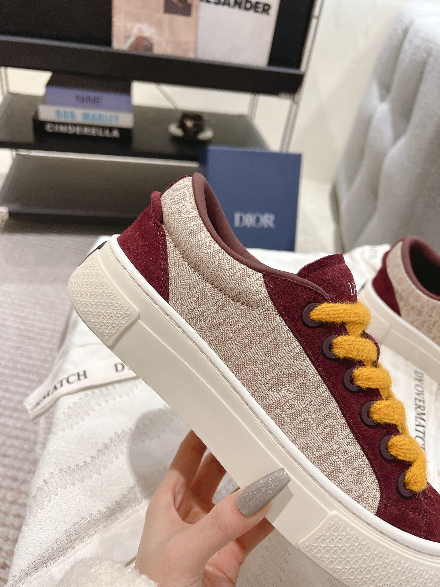 Burgundy and beige low-top sneaker with yellow laces and white sole, side view.