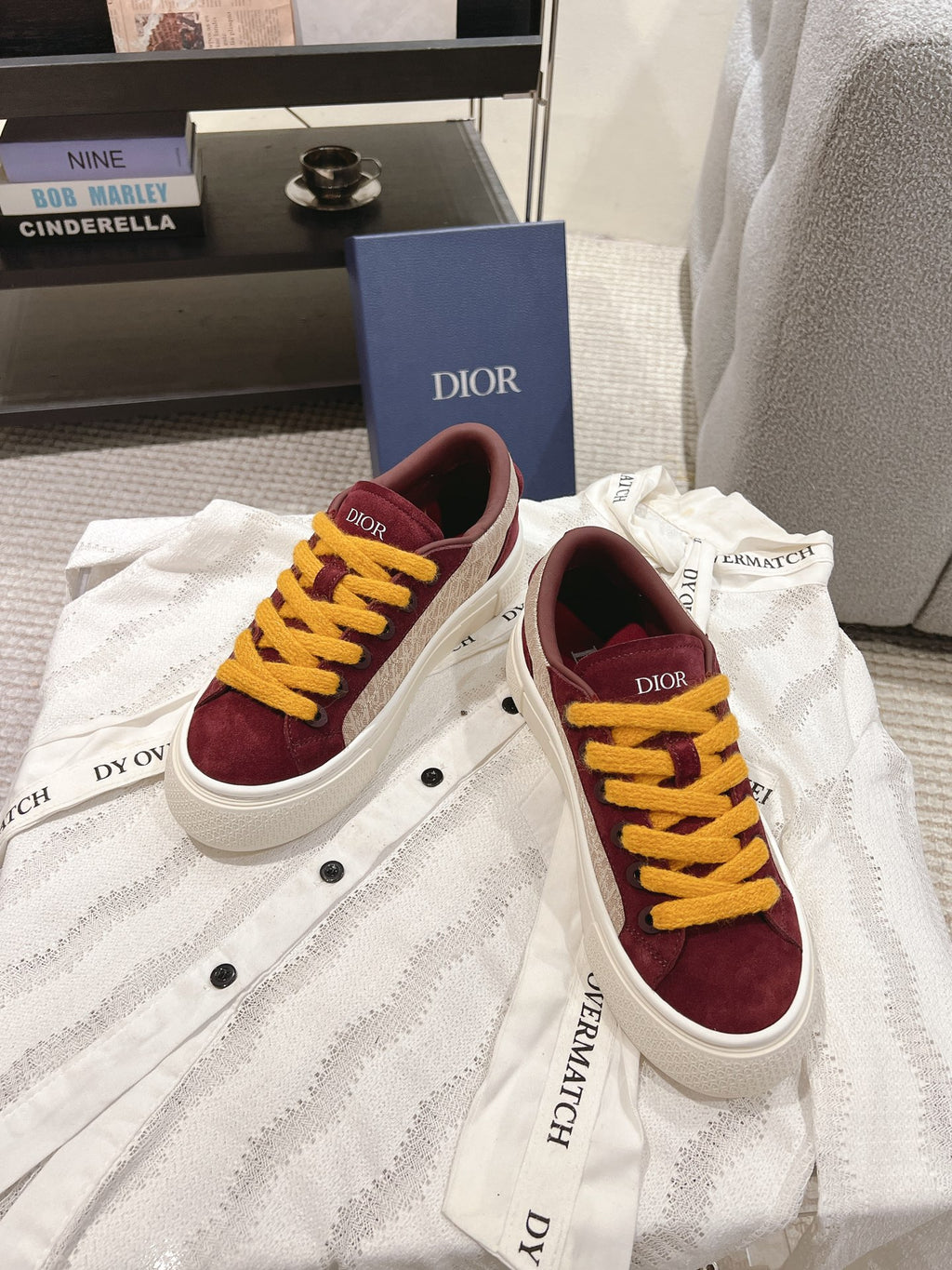 Burgundy low-top sneakers with yellow laces and white sole, front and side angle, unisex.