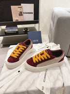 Burgundy sneakers with yellow laces and white sidewall, angled view, unisex.
