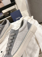 Gray Dior unisex lace-up sneakers, two shoes angled, textured upper and sole