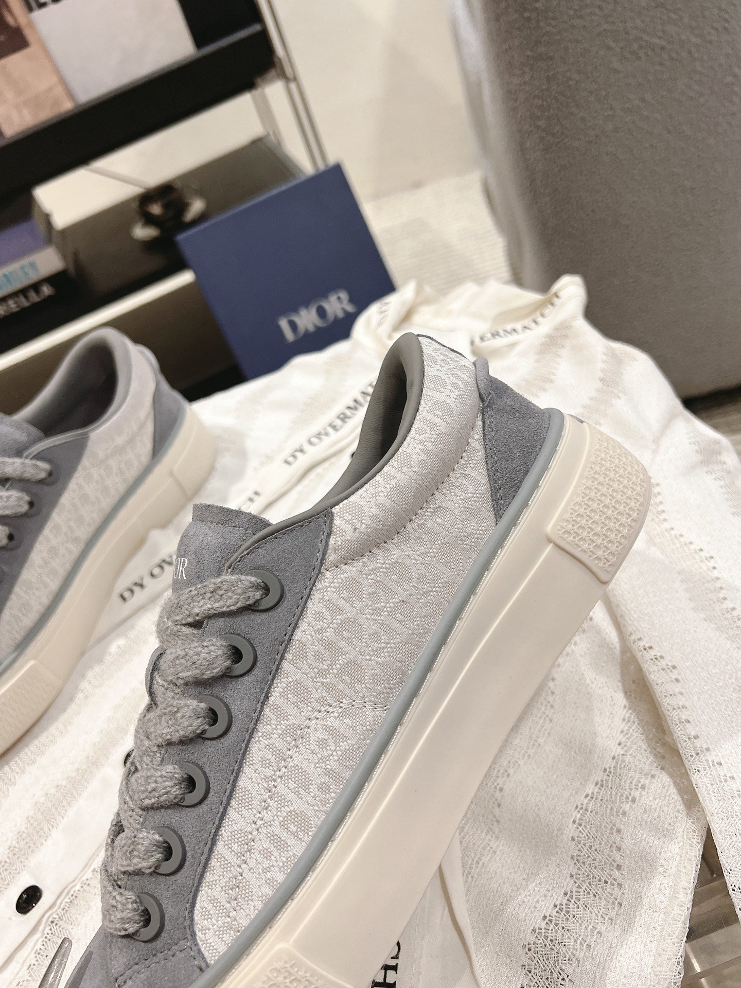 Gray Dior unisex lace-up sneakers, two shoes angled, textured upper and sole