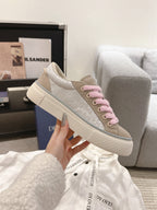 Low-top sneaker with pink laces, beige textured upper, chunky white sole, DIOR branding