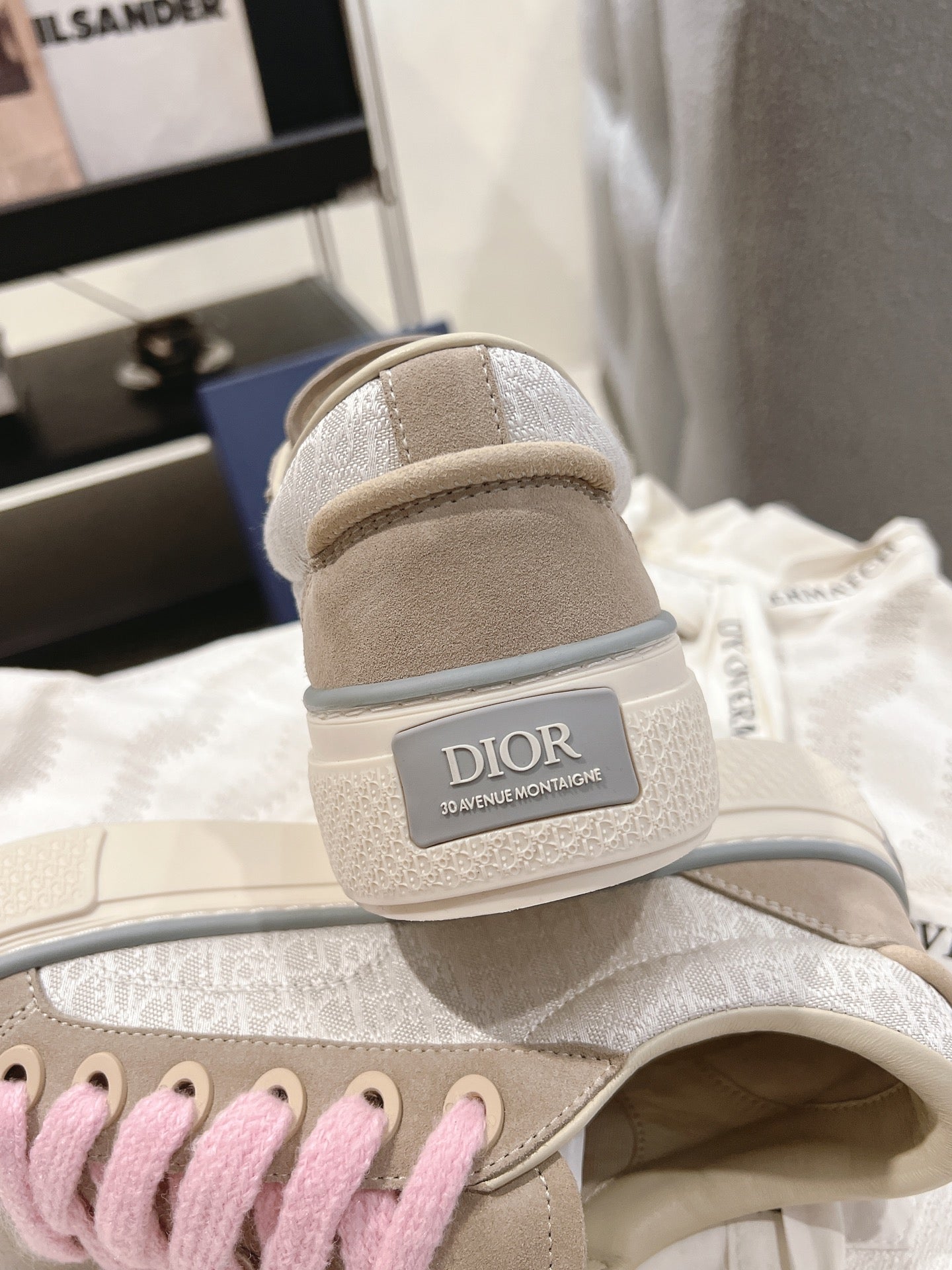 Back view of light beige sneaker with pink laces and DIOR logo on heel