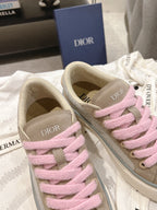Two low-top sneakers with pink laces, beige uppers, and DIOR logo on side panels