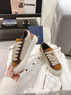 Pair of white and tan low-top sneakers with brown suede panels and lace-up front