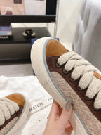 Side view of tan and brown low-top sneakers with white sole and gray laces