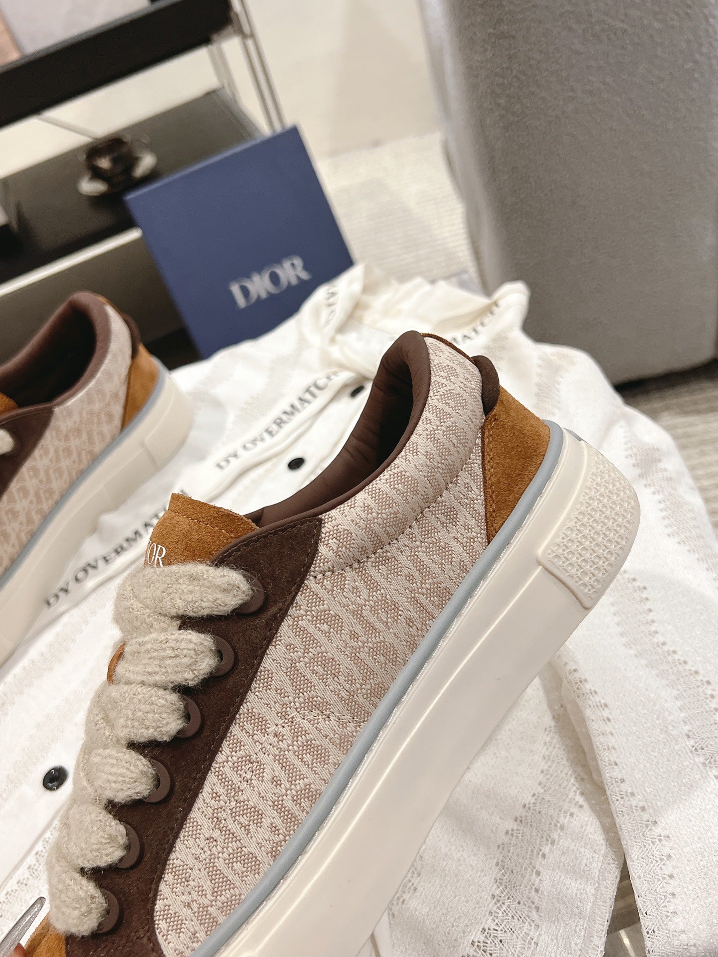 Tan-brown low-top sneakers with textured upper, white sidewall, and lace-up closure