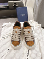 Pair of beige and brown low-top sneakers with white rubber sole and lace-up front