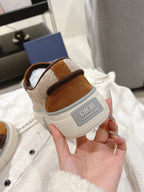Heel view of tan and brown low-top sneakers with DIOR logo patch and white sole