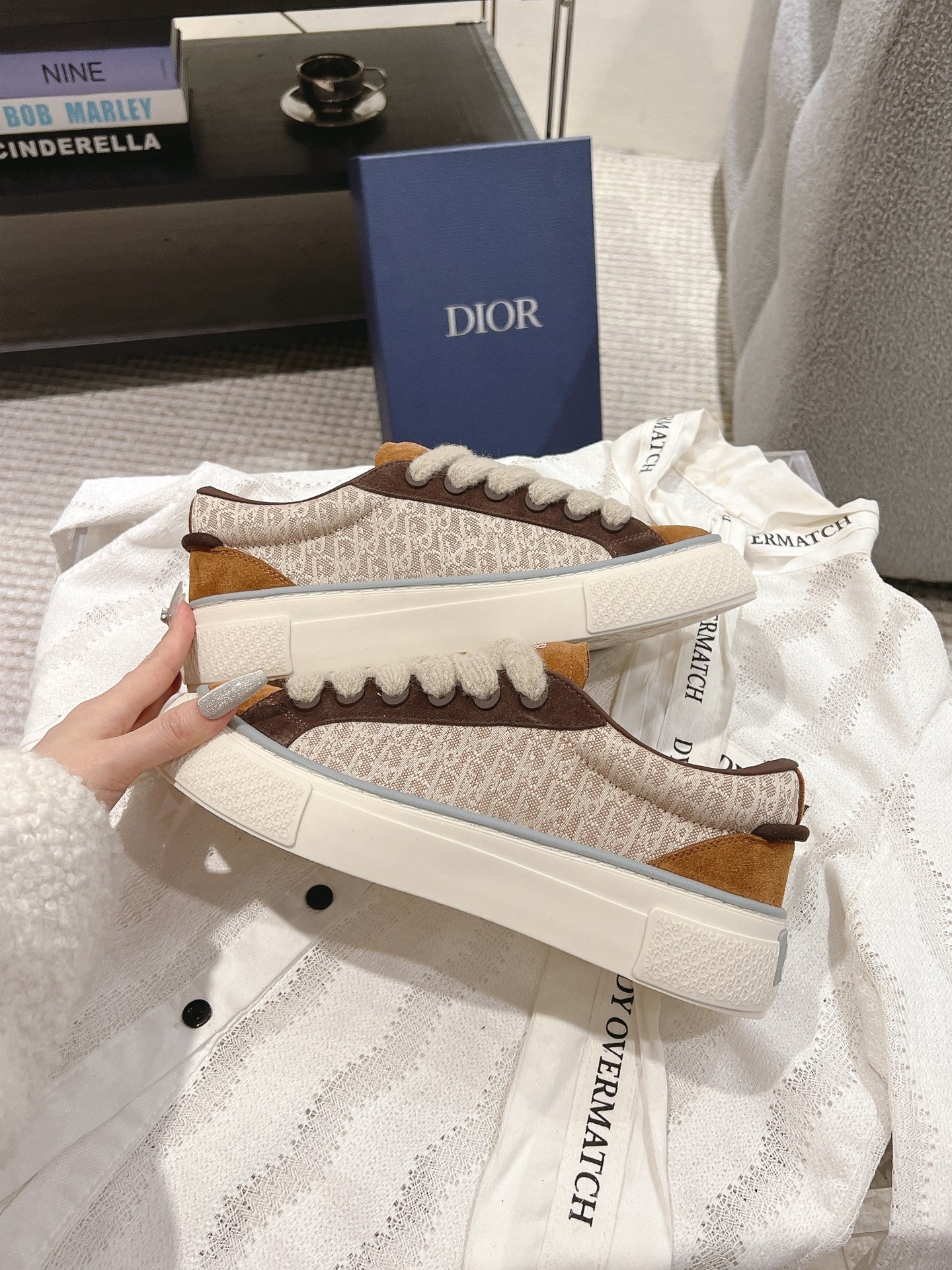 Front view of tan and brown low-top sneakers with beige laces and white rubber toe
