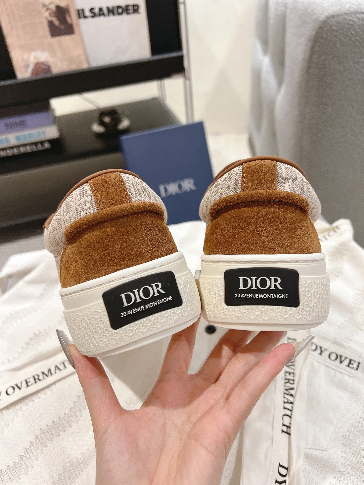 Pair of tan sneakers from the heel with white DIOR branding patches