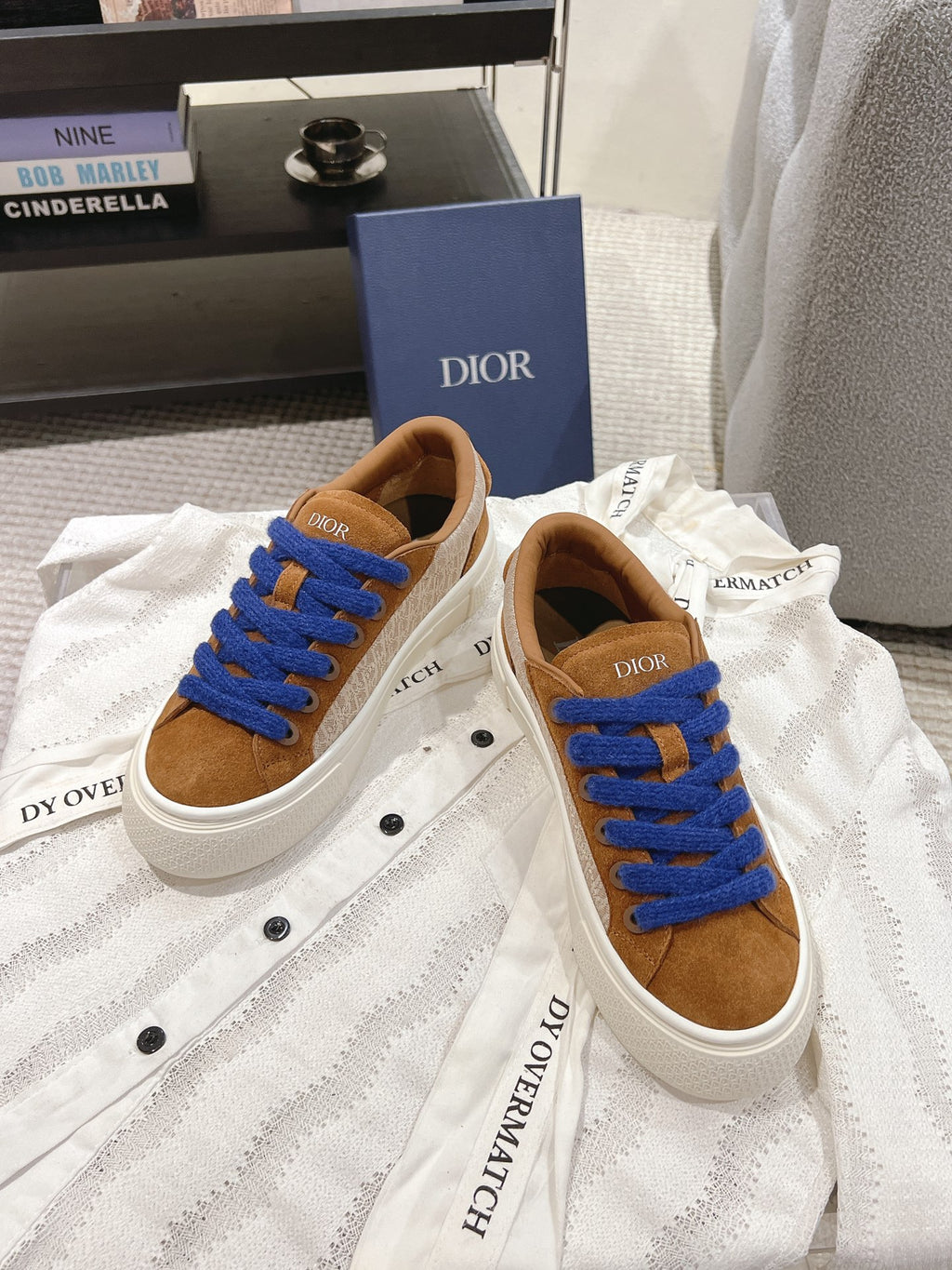 Tan sneakers with blue laces and white soles, Dior branding on tongue and heel