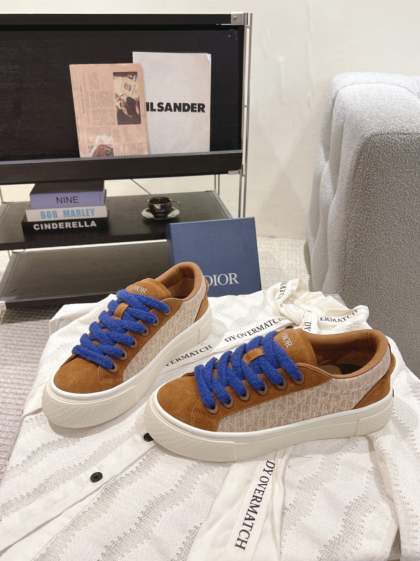 Brown-and-tan sneaker with blue laces, white platform sole, suede upper