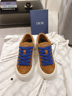 Tan low-top sneaker with bright blue laces and white rubber sole, Dior tongue patch
