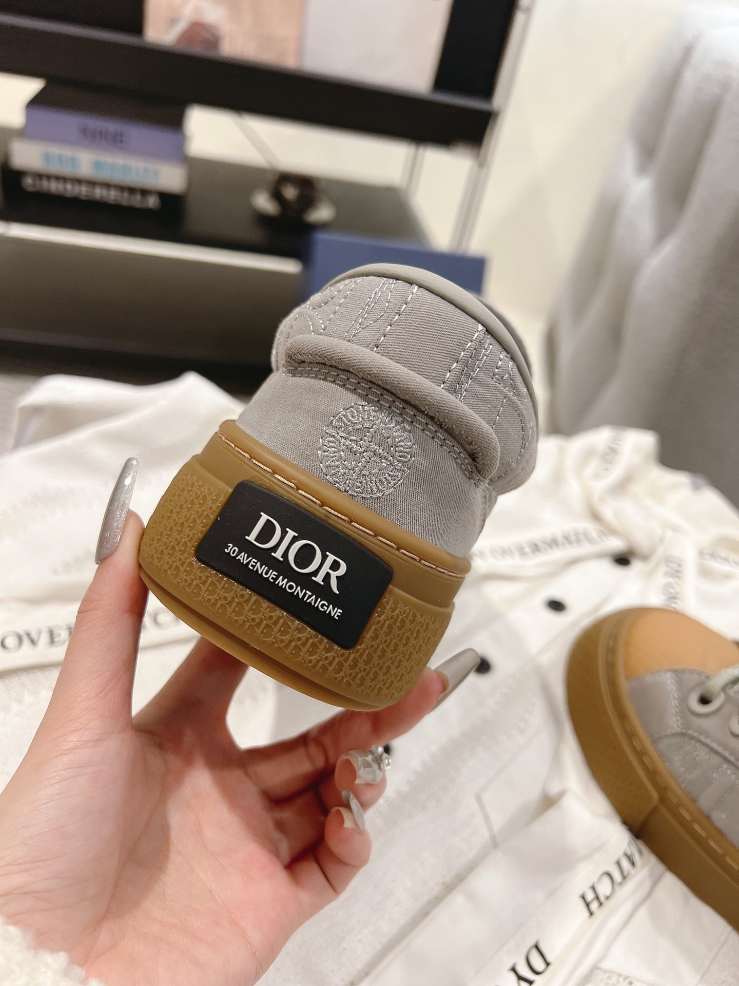 Dior unisex sneaker heel detail, gray upper with tan rubber sole and Dior logo