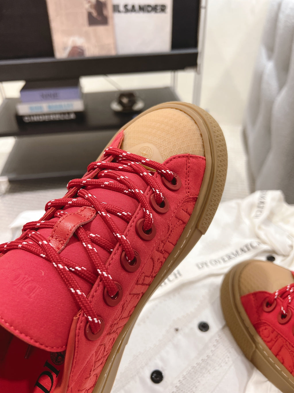 Close-up of red lace-up sneaker with tan sole, visible eyelets and laces