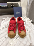 Red lace-up low-top sneakers with tan rubber sole, shown as a pair
