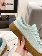 Light blue lace-up sneaker side profile with tan gum sole and textured upper
