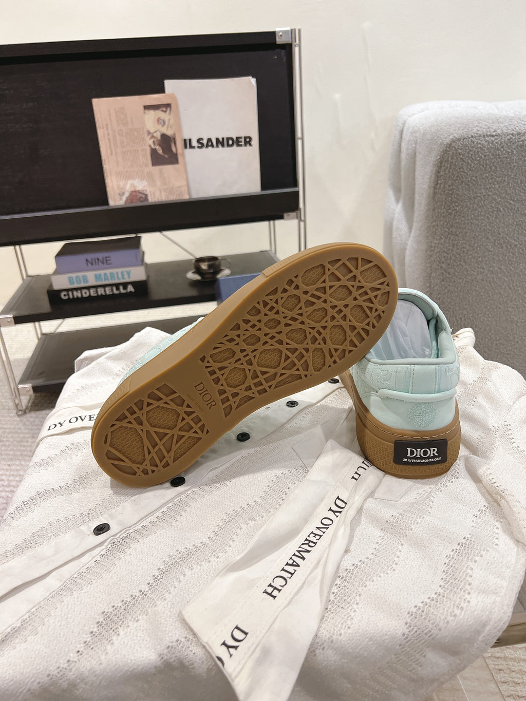 Light blue sneakers showing patterned tan outsole with Dior on heel