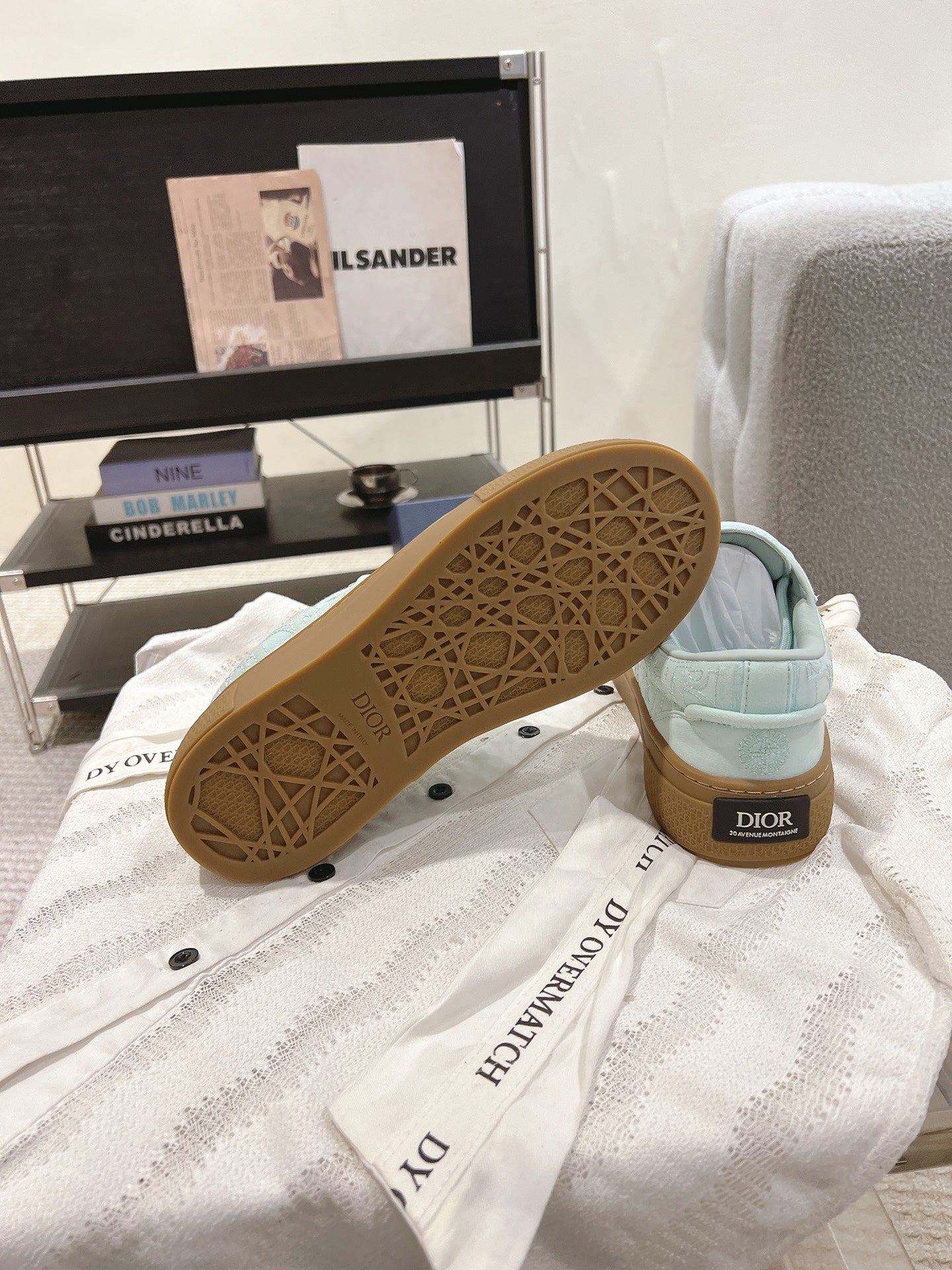Light blue sneakers showing patterned tan outsole with Dior on heel