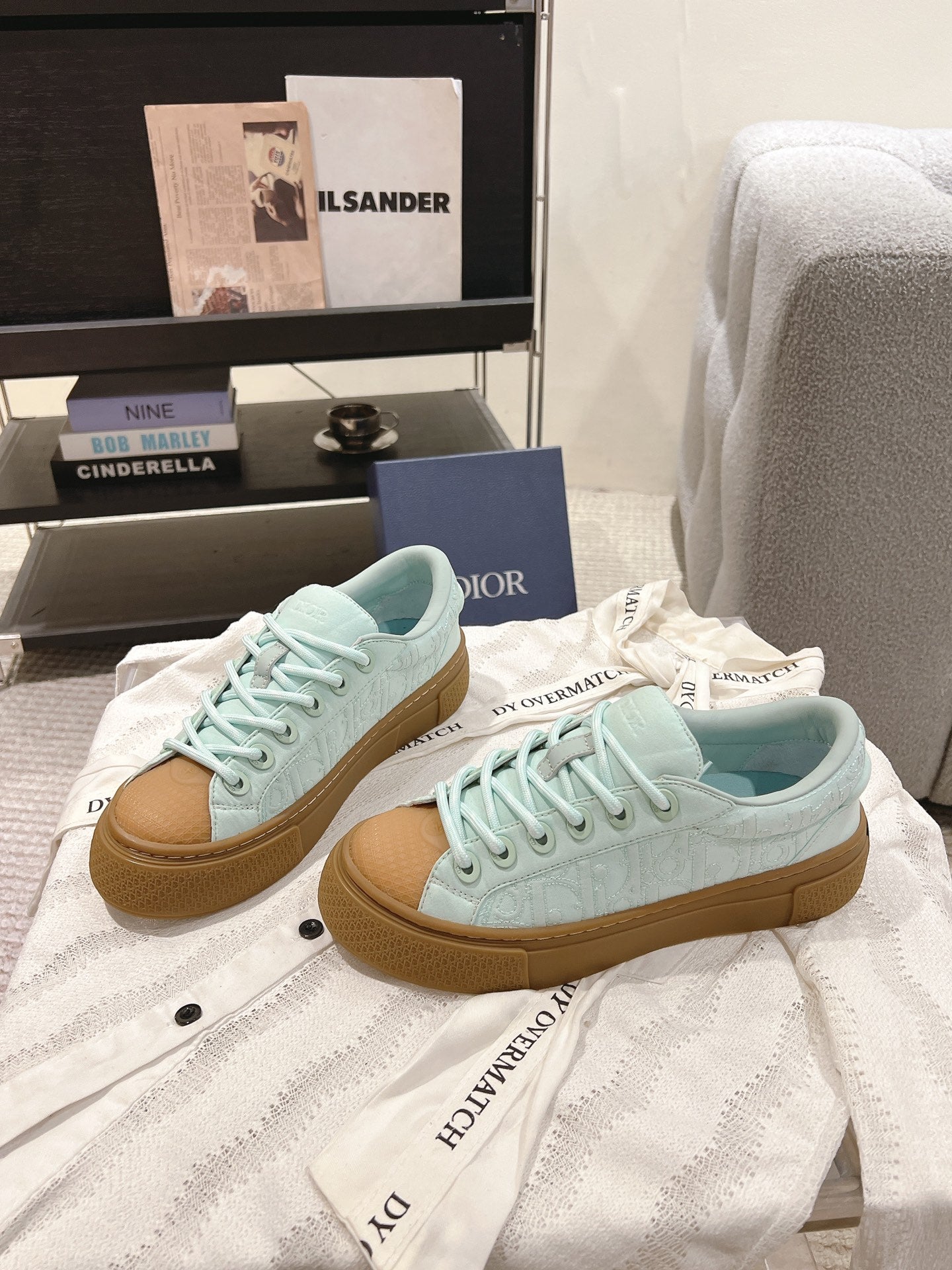 Pair of light blue lace-up sneakers with tan gum sole, side view