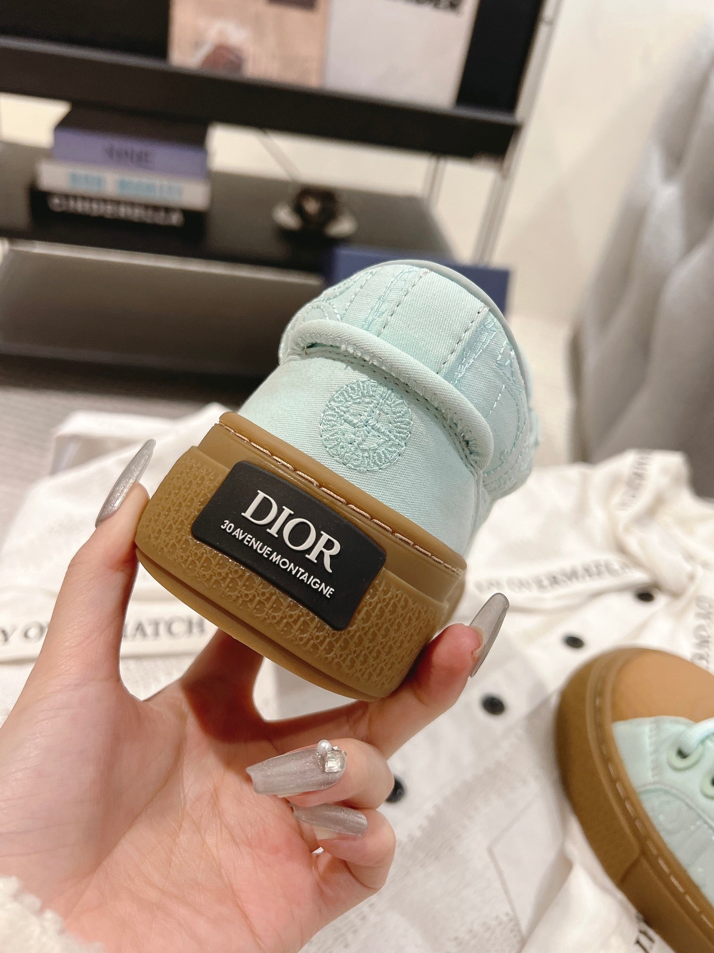 Light blue sneaker heel with Dior label on tan rubber sole