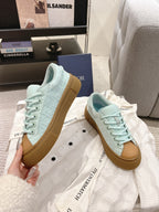 Light blue lace-up sneakers with tan gum sole, front angled view