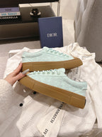 Light blue lace-up sneakers laid flat, showing tan gum outsole edges