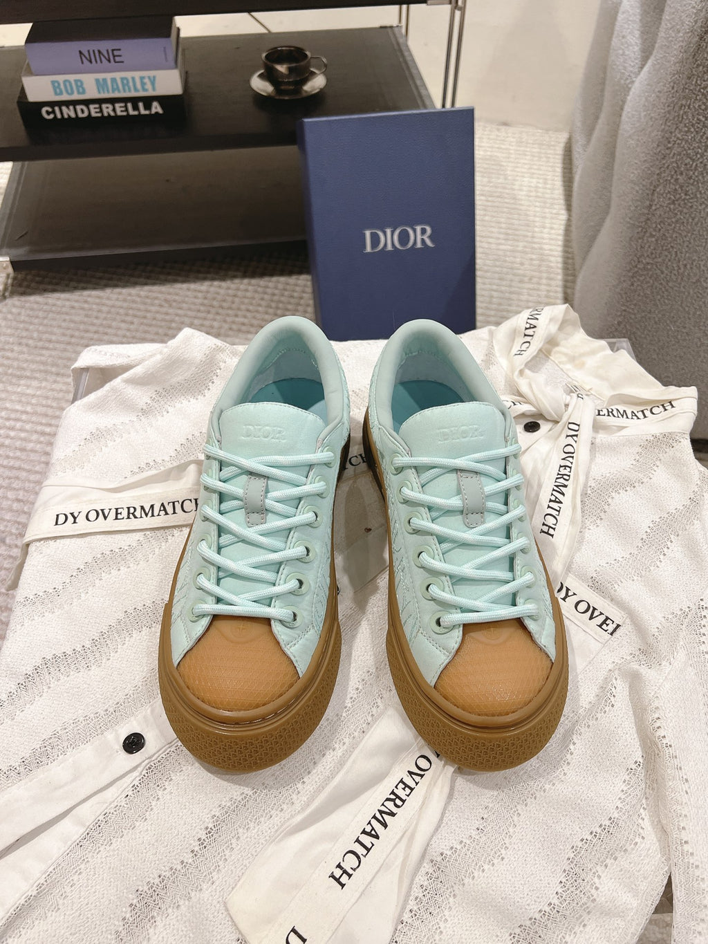 Light blue lace-up sneakers with tan gum sole and Dior branding on side