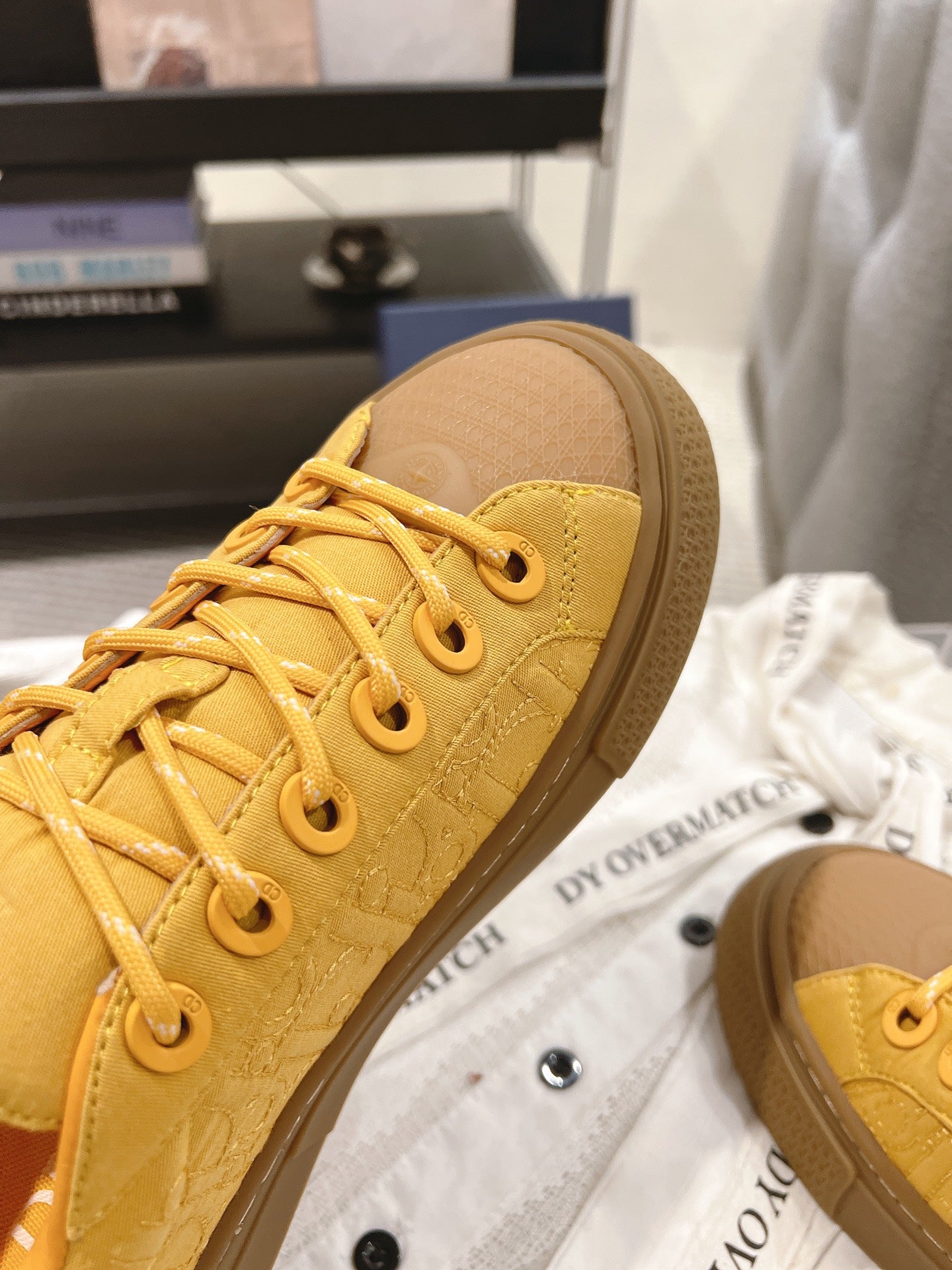 Yellow low-top sneaker toe and laces detail with stitched texture