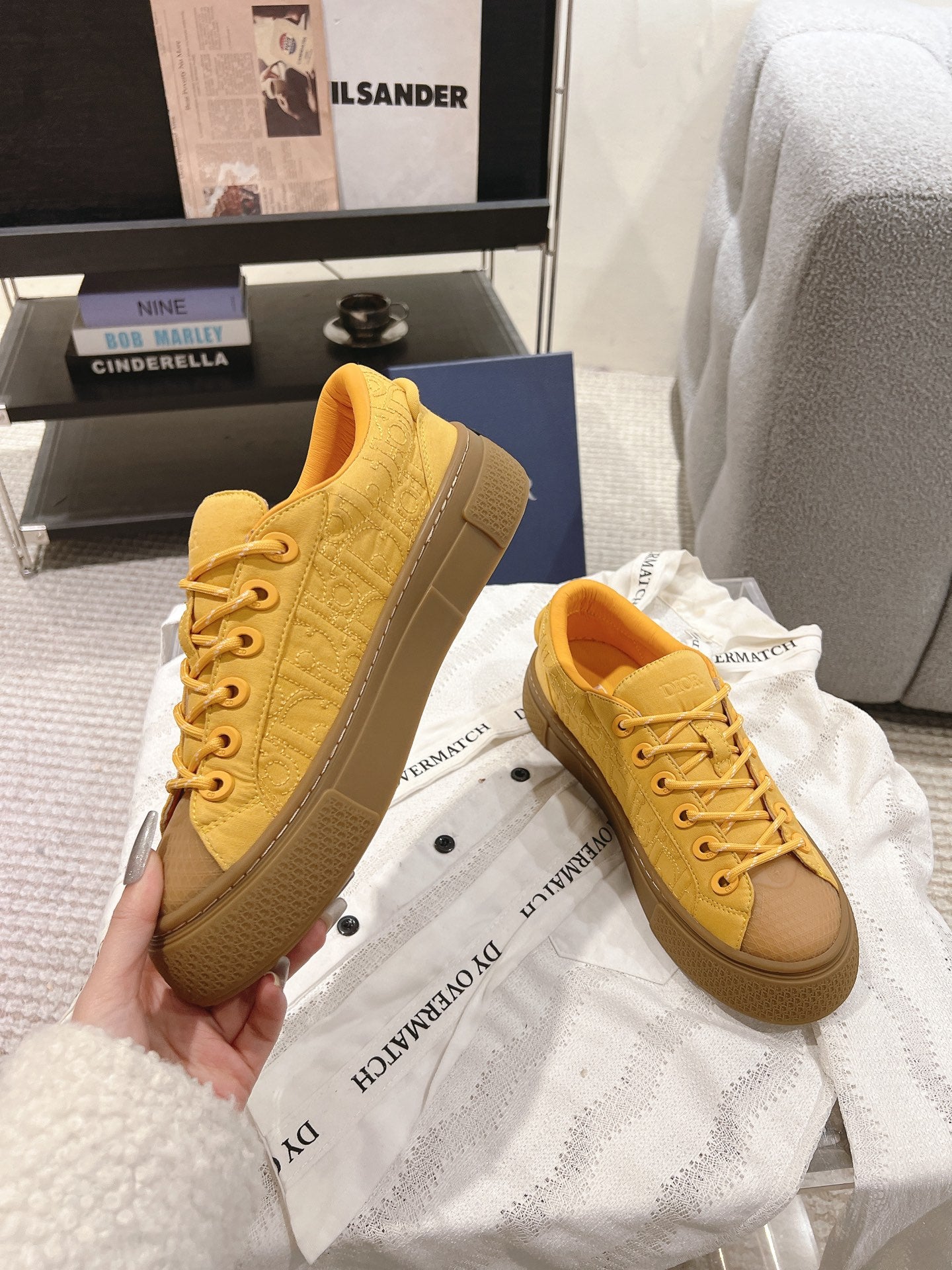 Yellow low-top unisex sneakers standing together on dust bags