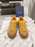 Yellow low-top unisex sneakers with lace-up closure and rubber sole