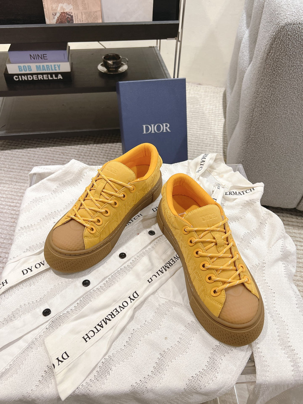 Pair of yellow lace-up low-top unisex sneakers on white dust bags