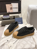 Black Dior sneakers with tan soles, lace-up design, side view