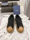 Black unisex Dior sneakers with tan sole and black lace-up front