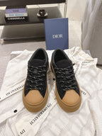 Black unisex Dior sneakers with tan sole and black lace-up front