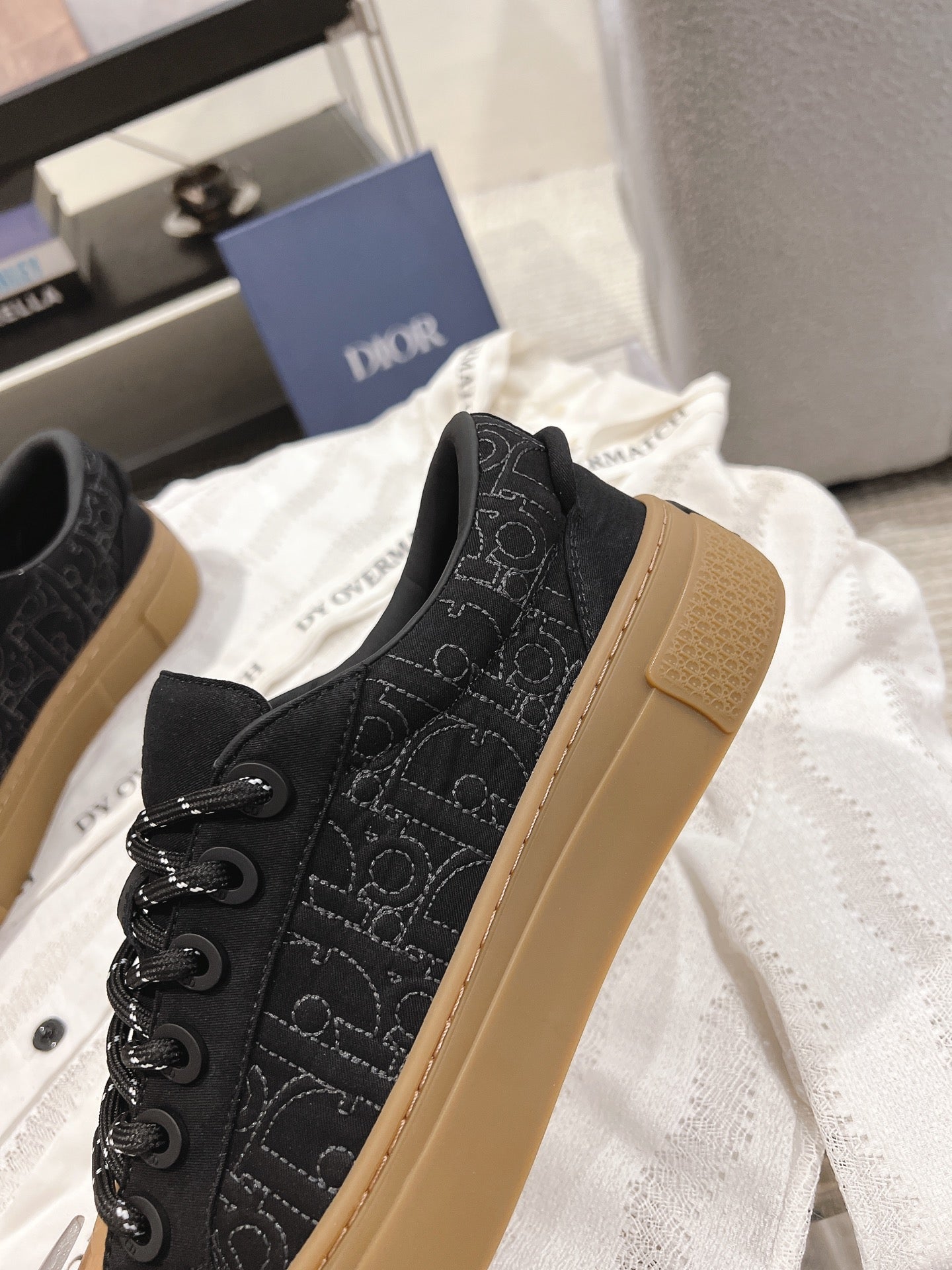 Black Dior slip-on sneakers with tan rubber sole and textured monogram