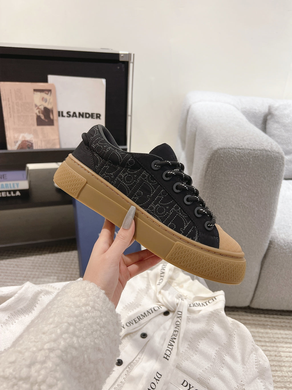 Black Dior low-top sneakers with tan rubber sole and lace-up closure