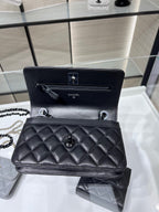 Black quilted leather flap bag open view with interior pocket and chain strap