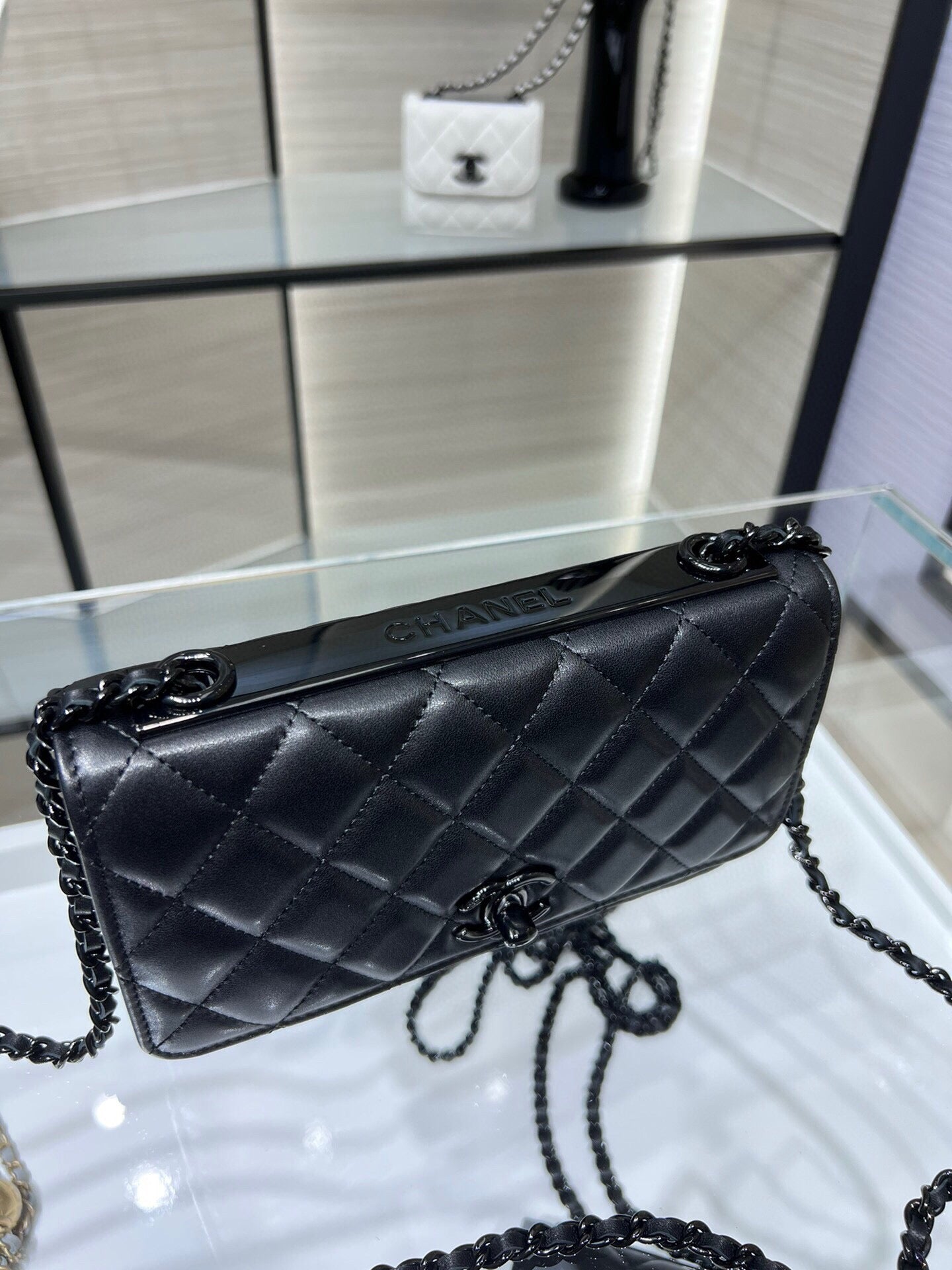 Black quilted leather Chanel-style shoulder bag with chain strap and front flap