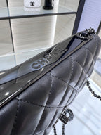 Black quilted leather flap bag with chain strap and curved front clasp