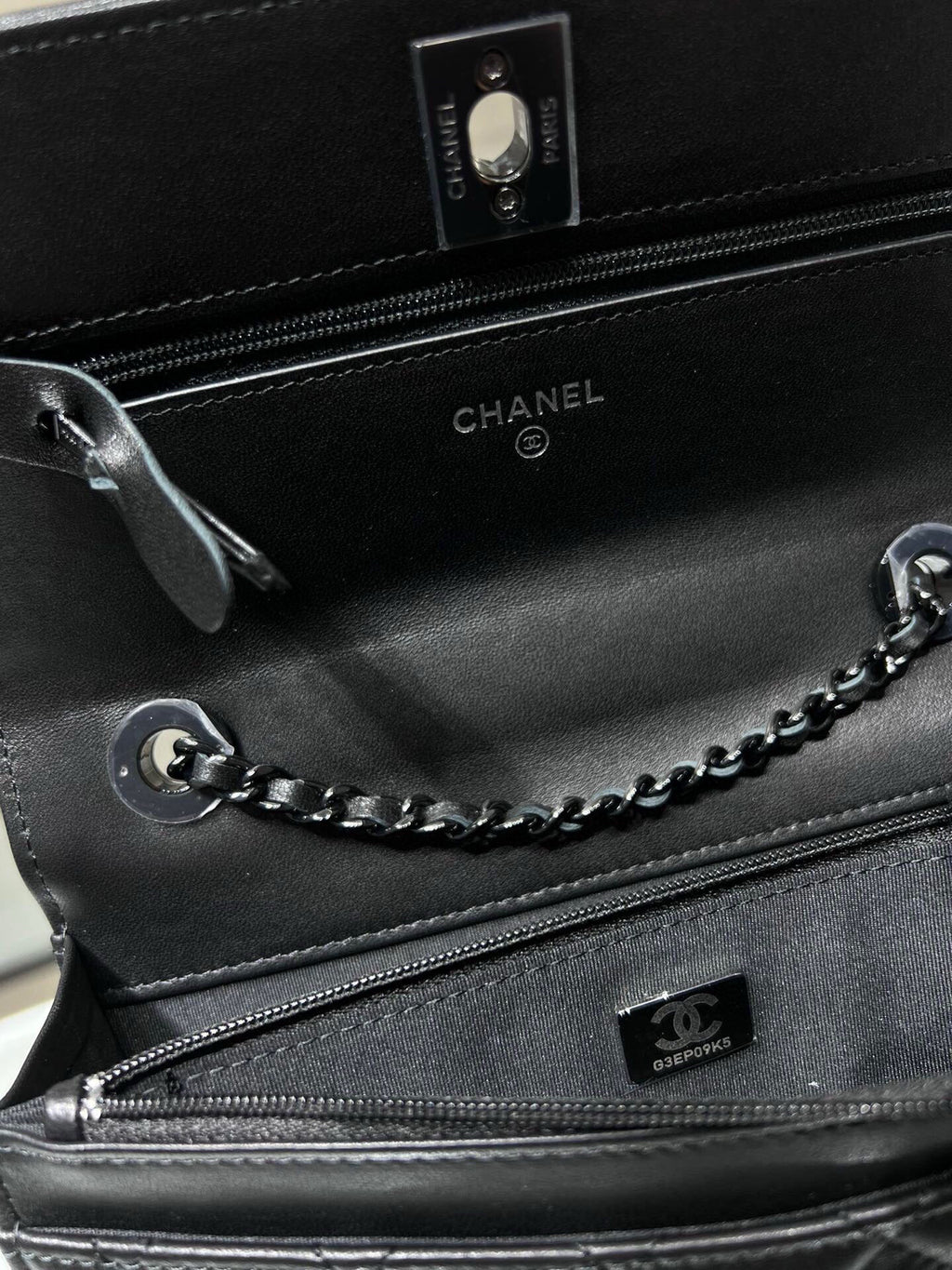 Black leather bag interior with zipper, CHANEL logo, and chain strap